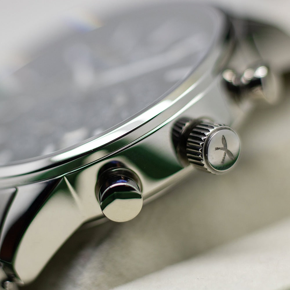 Close-up of silver stainless steel watch crown and pusher